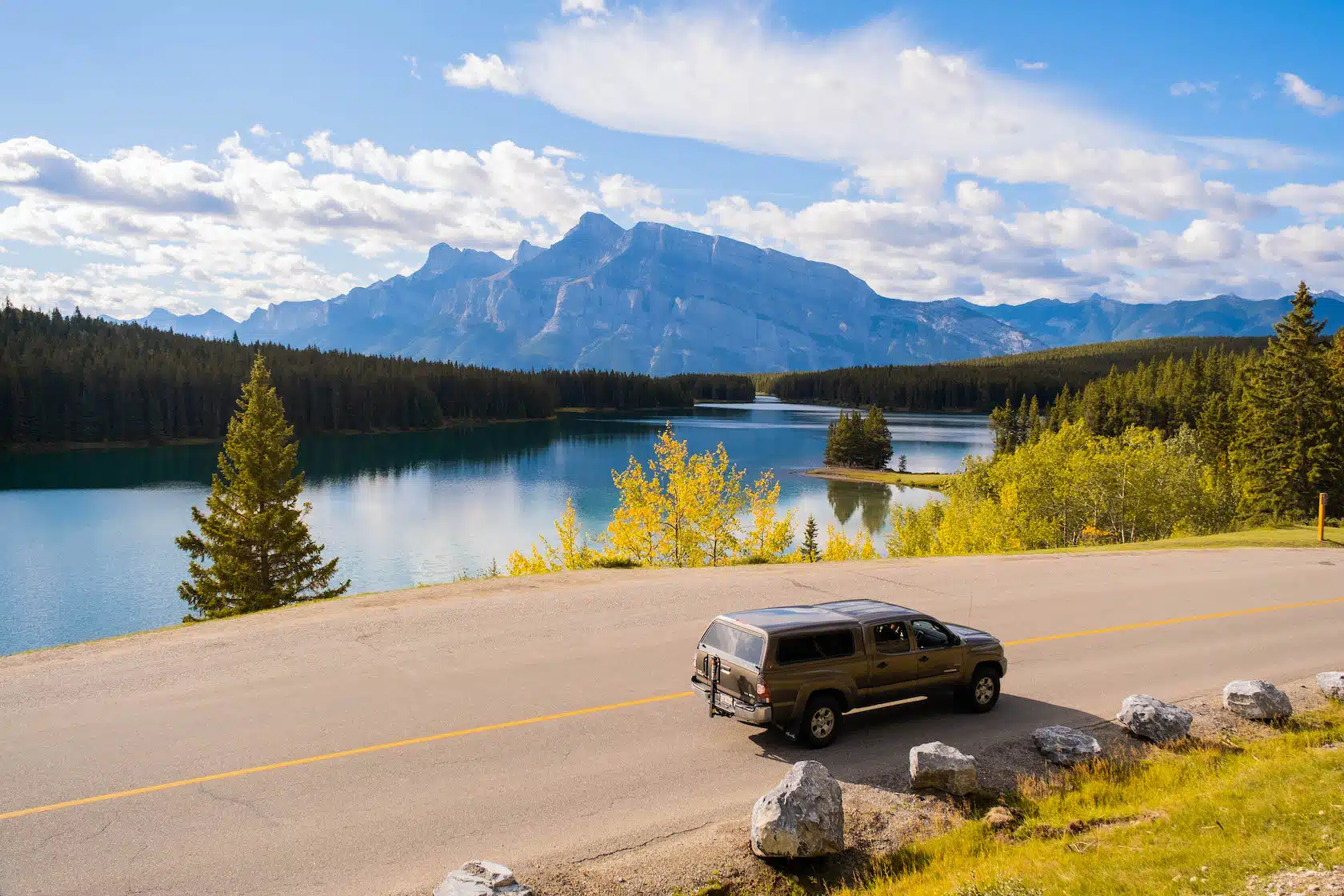 Vehicle stopped along the Lake Minnewanka Loop road overlooking Two Jack Lake in autumn