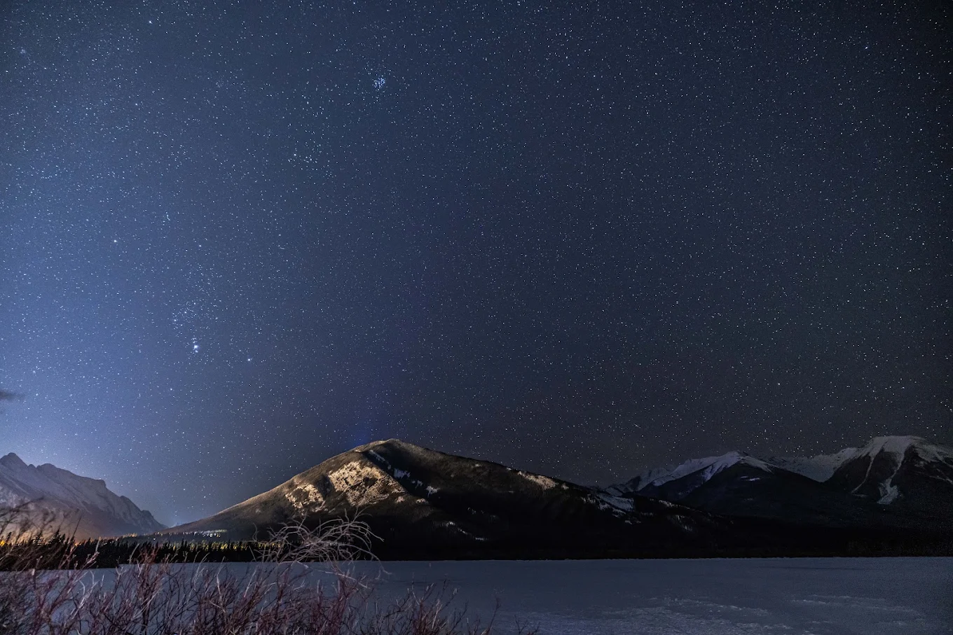 Starry night sky over the mountains near Vermilion Lakes in winter
