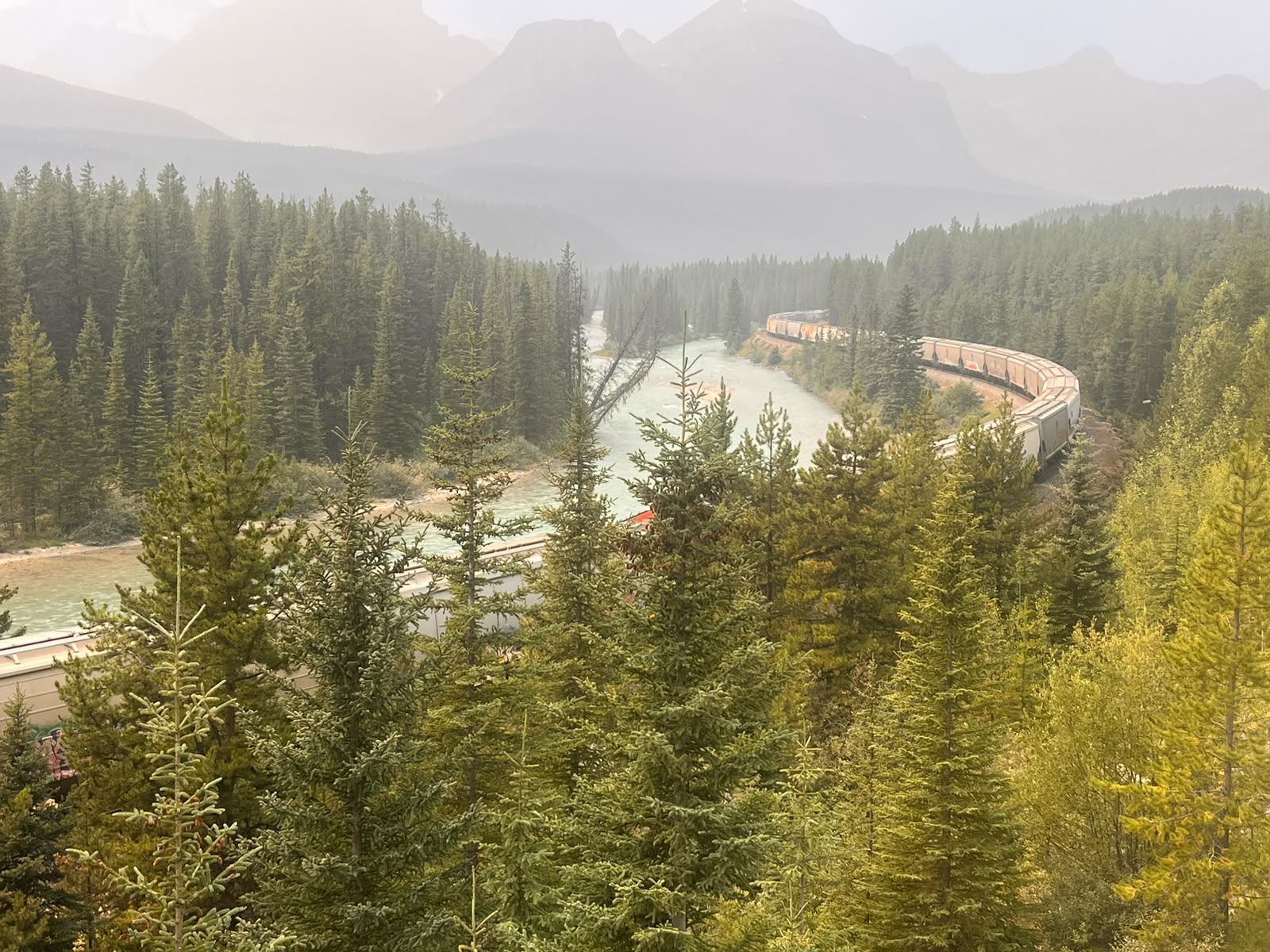Freight train curving beside the Bow River at Morant&rsquo;s Curve
