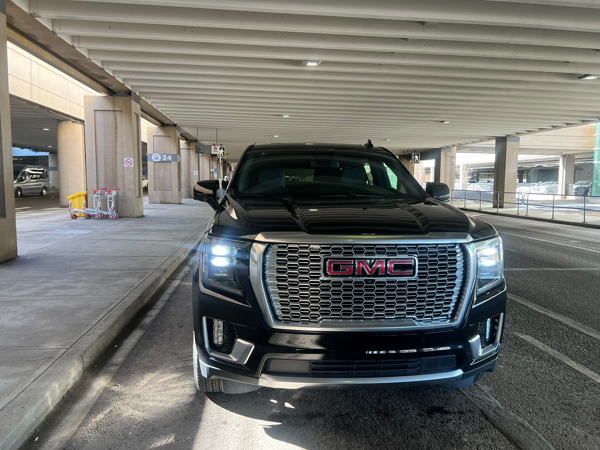 Black GMC Business SUV waiting at the Calgary Airport terminal curbside for a hotel transfer pickup