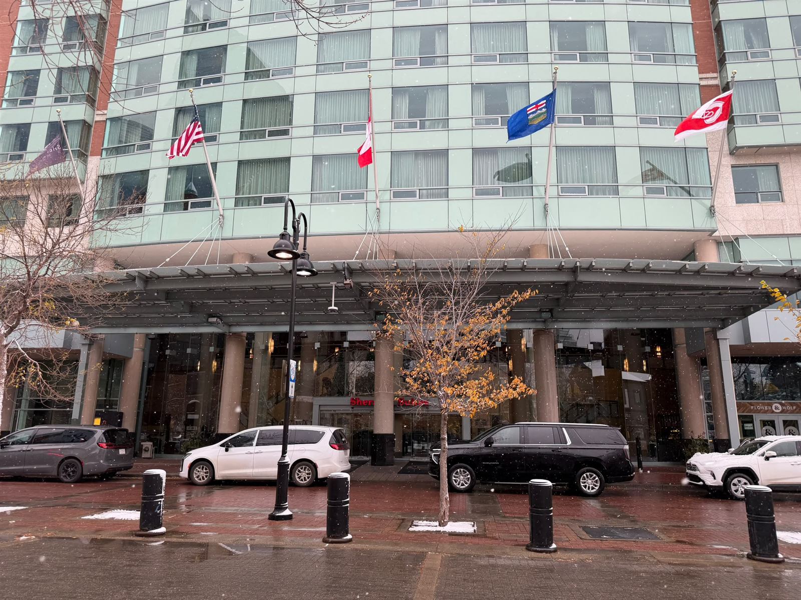 Entrance canopy, flags and passenger loading area at Sheraton Suites Calgary Eau Claire in downtown Calgary