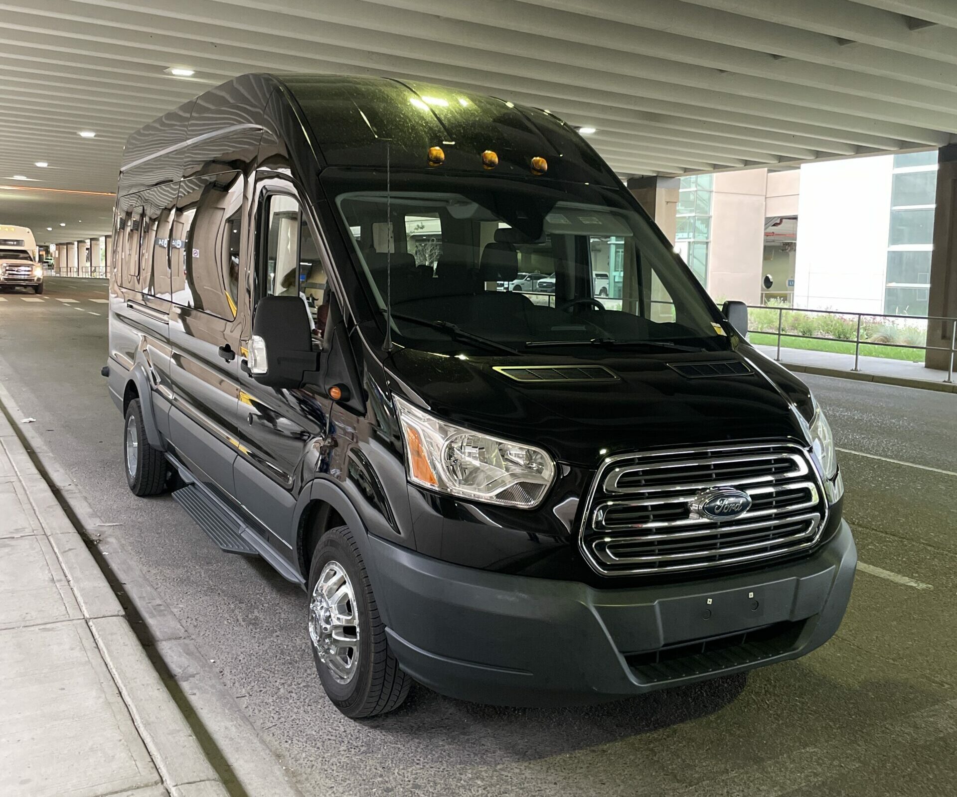 Red Mile Limousine black Ford Transit passenger van at the Calgary Airport curb, used for private Calgary to Medicine Hat group transfers