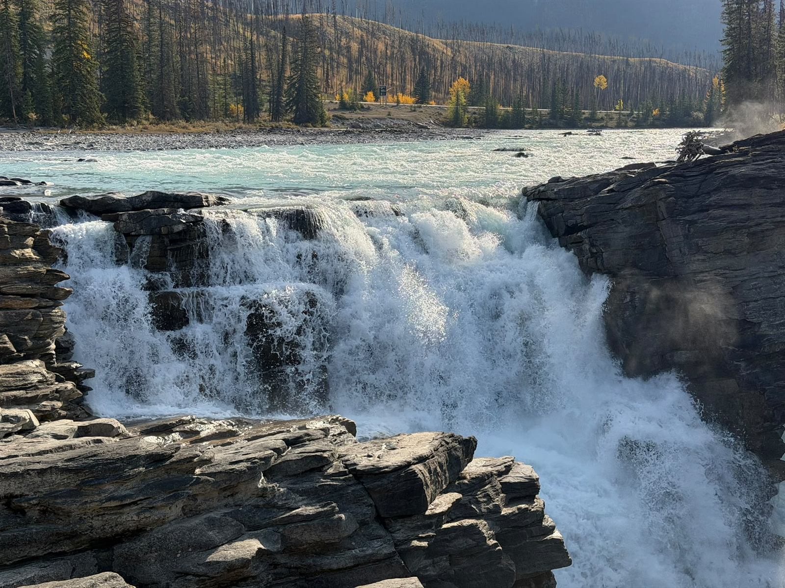 Close view of Athabasca Falls crashing over layered rock ledges