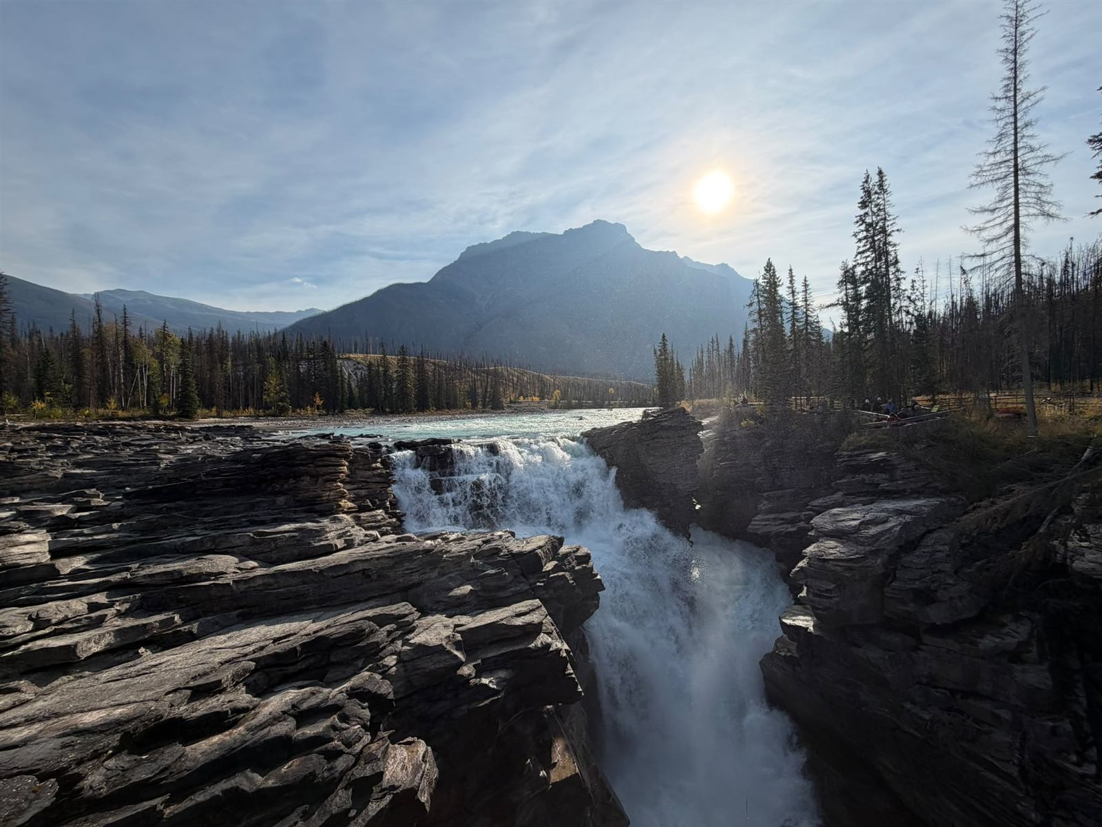 Athabasca River dropping into its narrow rock gorge below Mount Kerkeslin, with the sun breaking through cloud