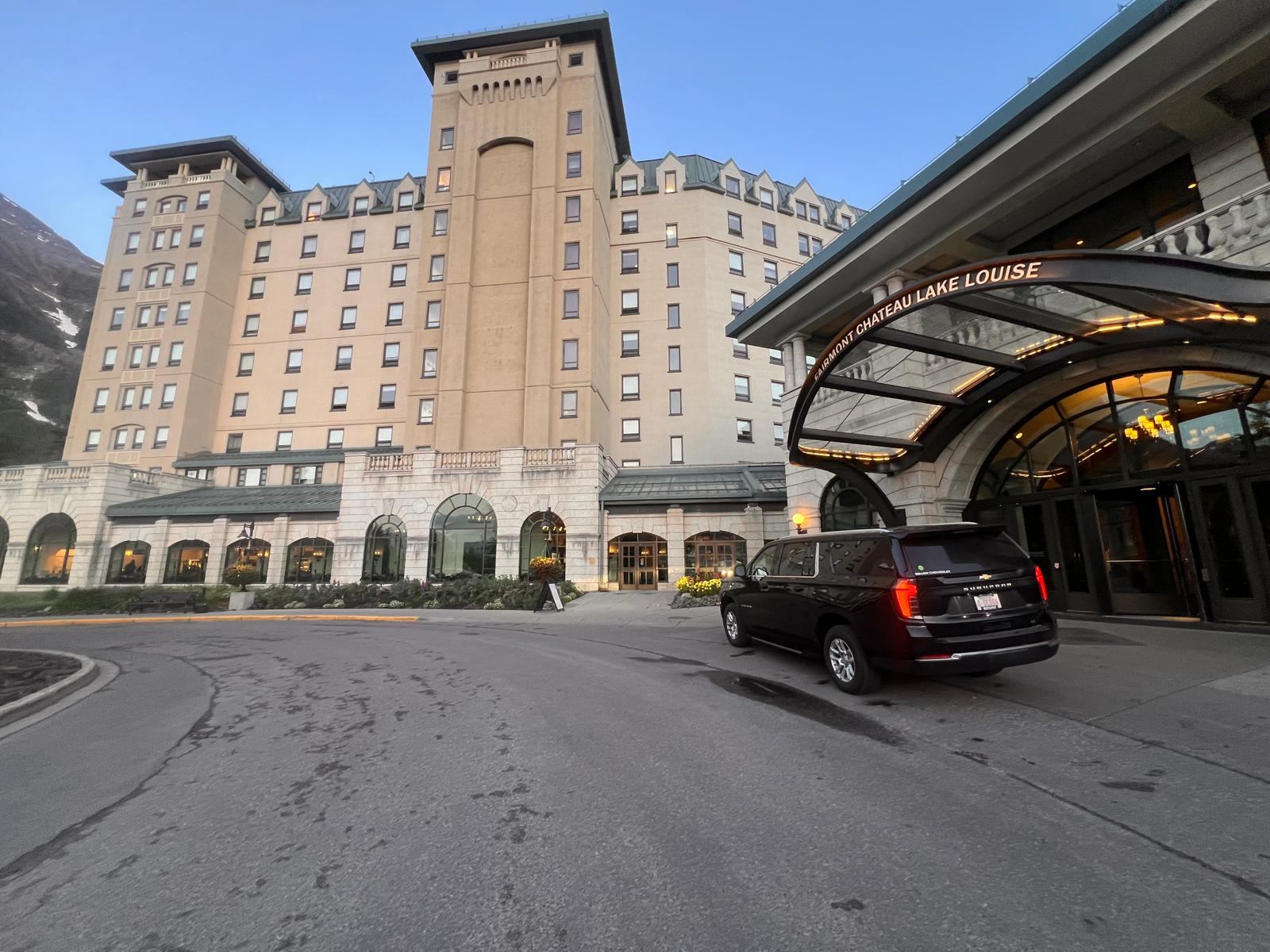 Red Mile Limousine Services SUV under the Fairmont Chateau Lake Louise porte-cochere, with the hotel tower above
