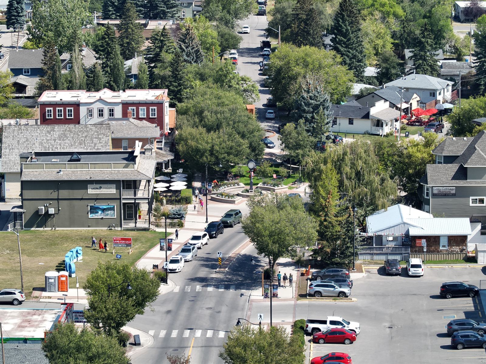 Aerial view of downtown Okotoks with its clock tower plaza, heritage storefronts and tree-lined streets