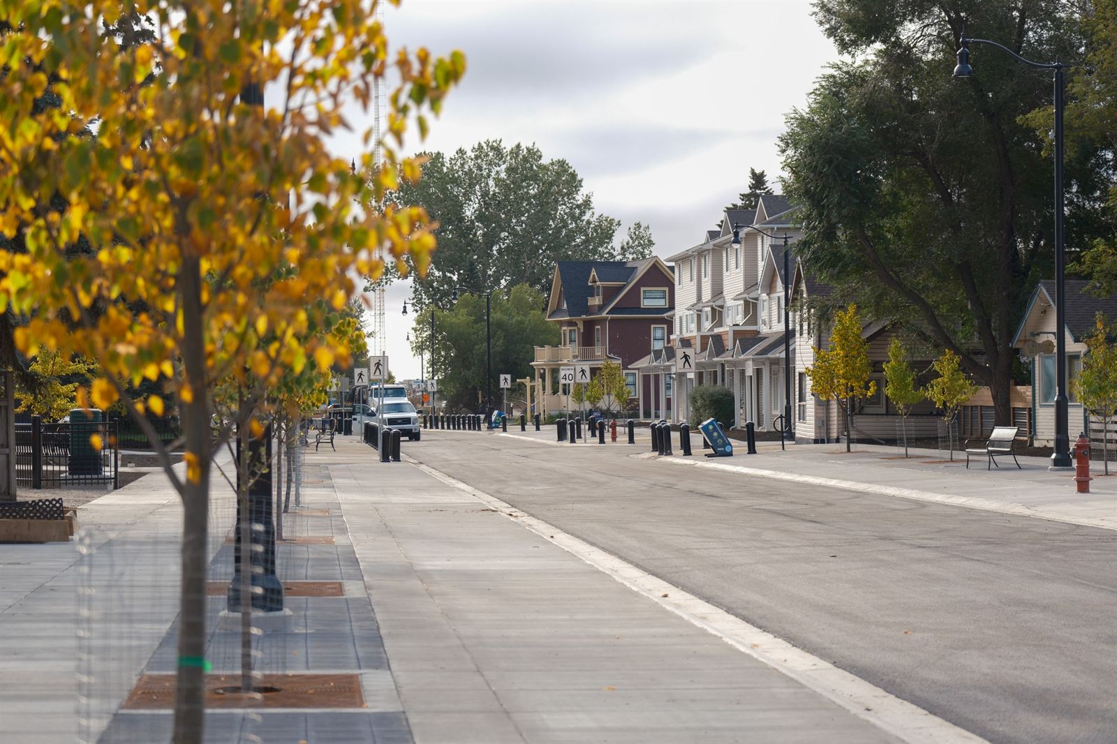 North Railway Street in downtown Okotoks with heritage-style homes, new sidewalks and autumn trees