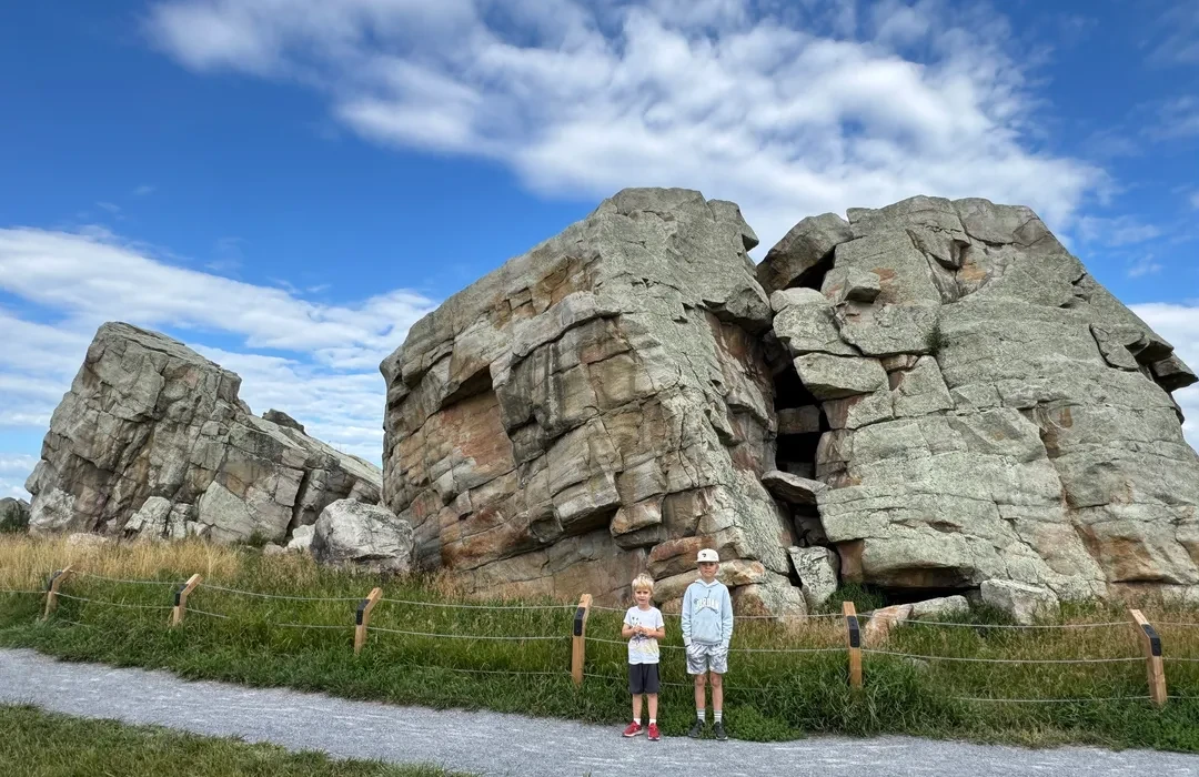 Two young visitors in front of the Okotoks Erratic, the giant glacial boulder known as Big Rock, west of Okotoks